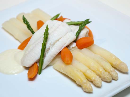 Asperges met gepocheerde scholfilet waarbij gestoofde worteltjes, aardappelpuree en geserveerd met witte wijnsaus